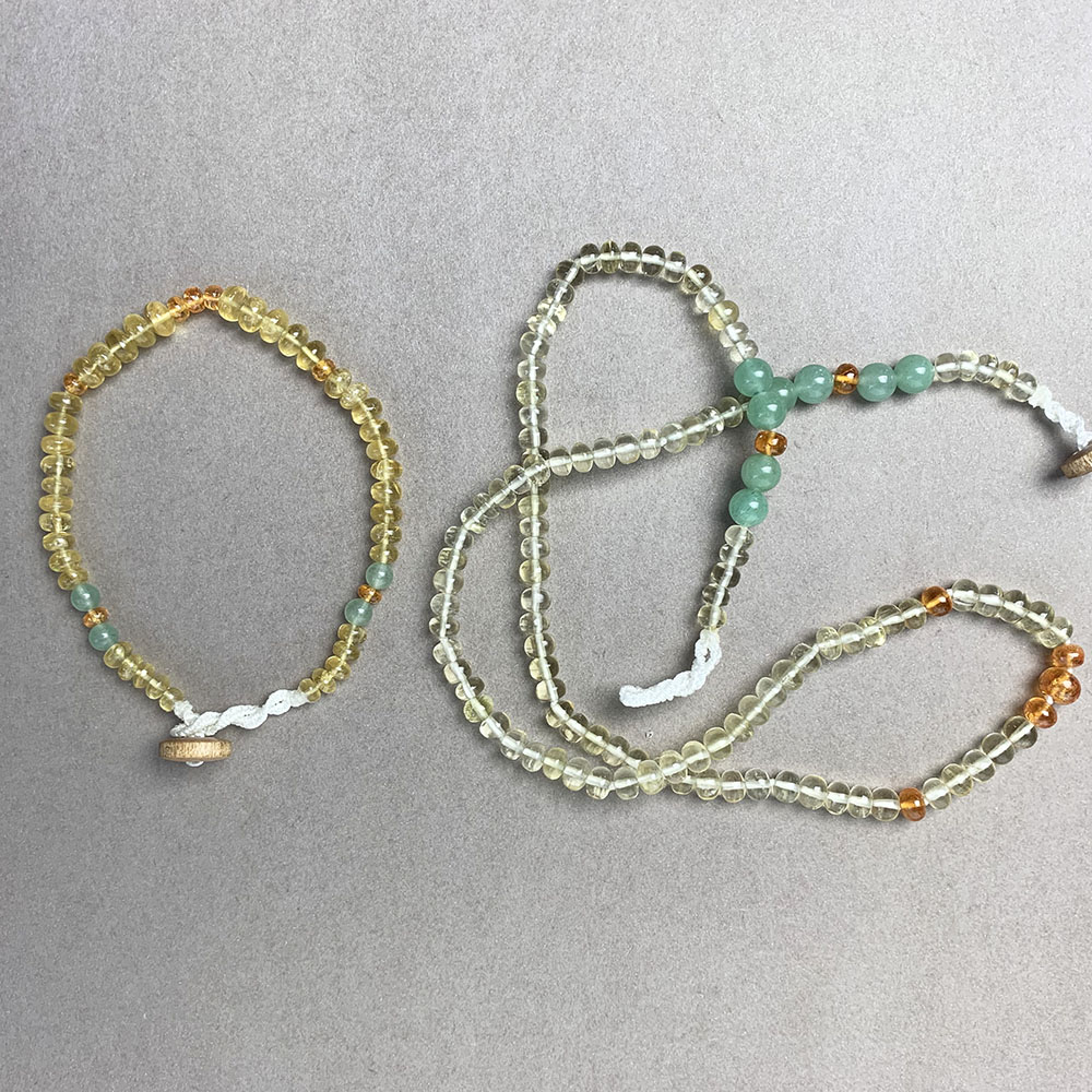 Golden Beryl gemstone bracelet and necklace with wood clasps lying flat