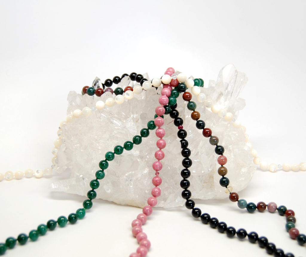 Foundation Five gemstone necklaces on a Quartz crystal cluster