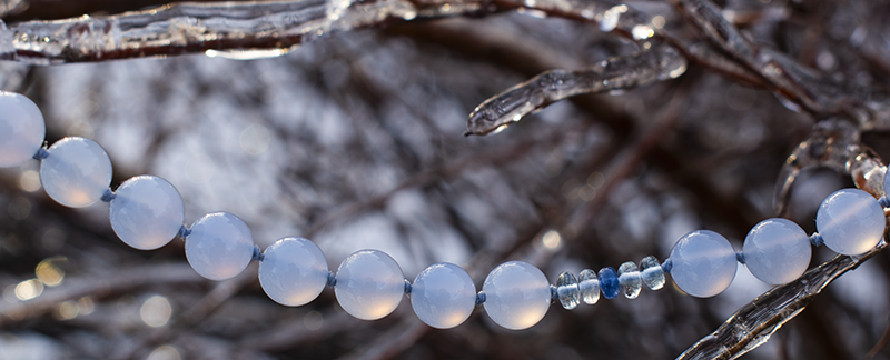 Blue Chalcedony gemstone necklace strung on icy branches