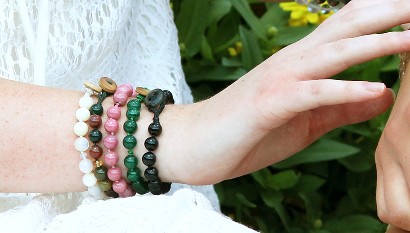 photo of five gemstone bracelets on woman's wrist