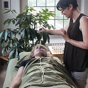 Practitioner working with the gemstones placed on a client