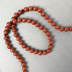 Red Jasper and Ruby necklace on beige table