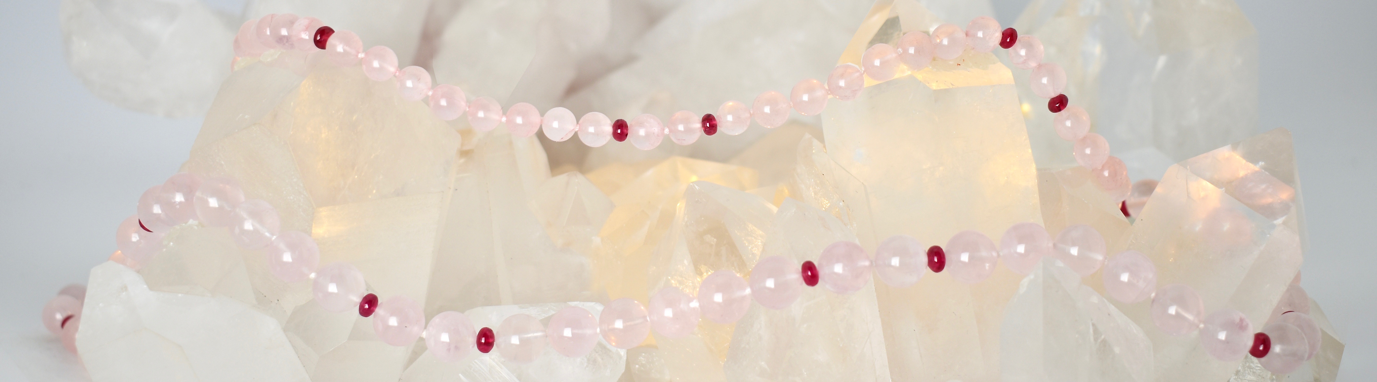 Rose Quartz & Red Spinel gemstone necklace on a Quartz crystal cluster