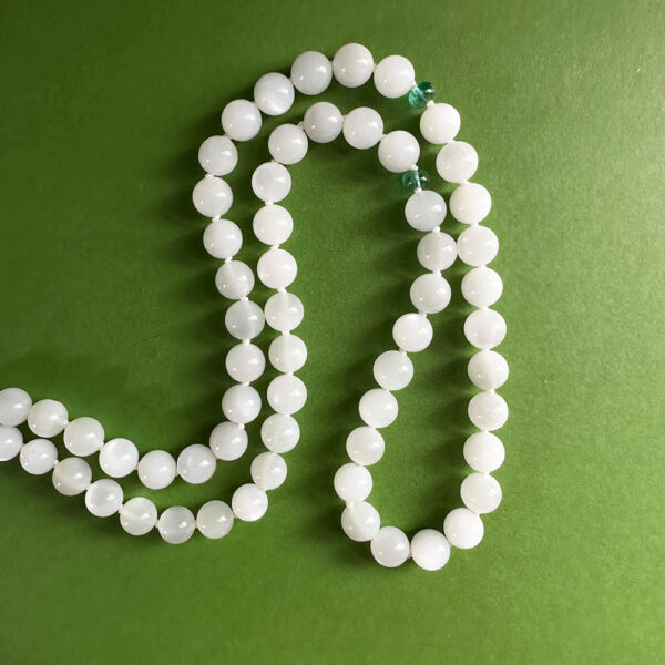 Brilliant White Flash Moonstone and Emerald necklace on green background