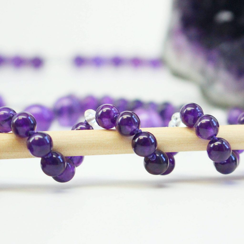 Healing gemstone Amethyst bracelet wrapped around a therapy wand