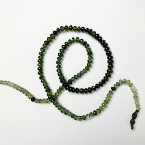 green tourmaline gemstone necklace in spirals on white background